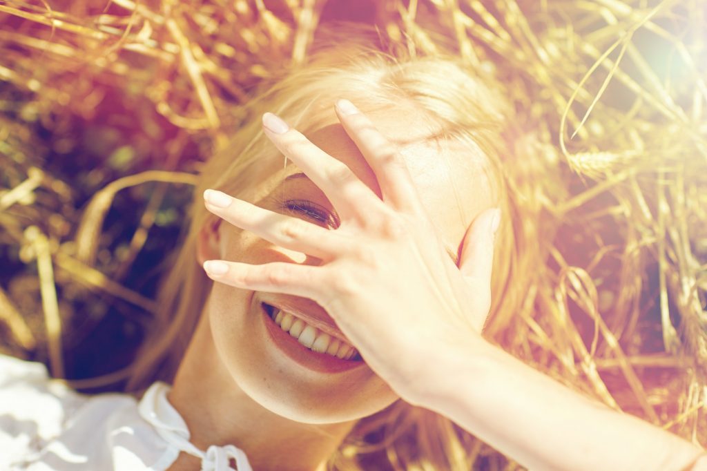 happy young woman lying on cereal field